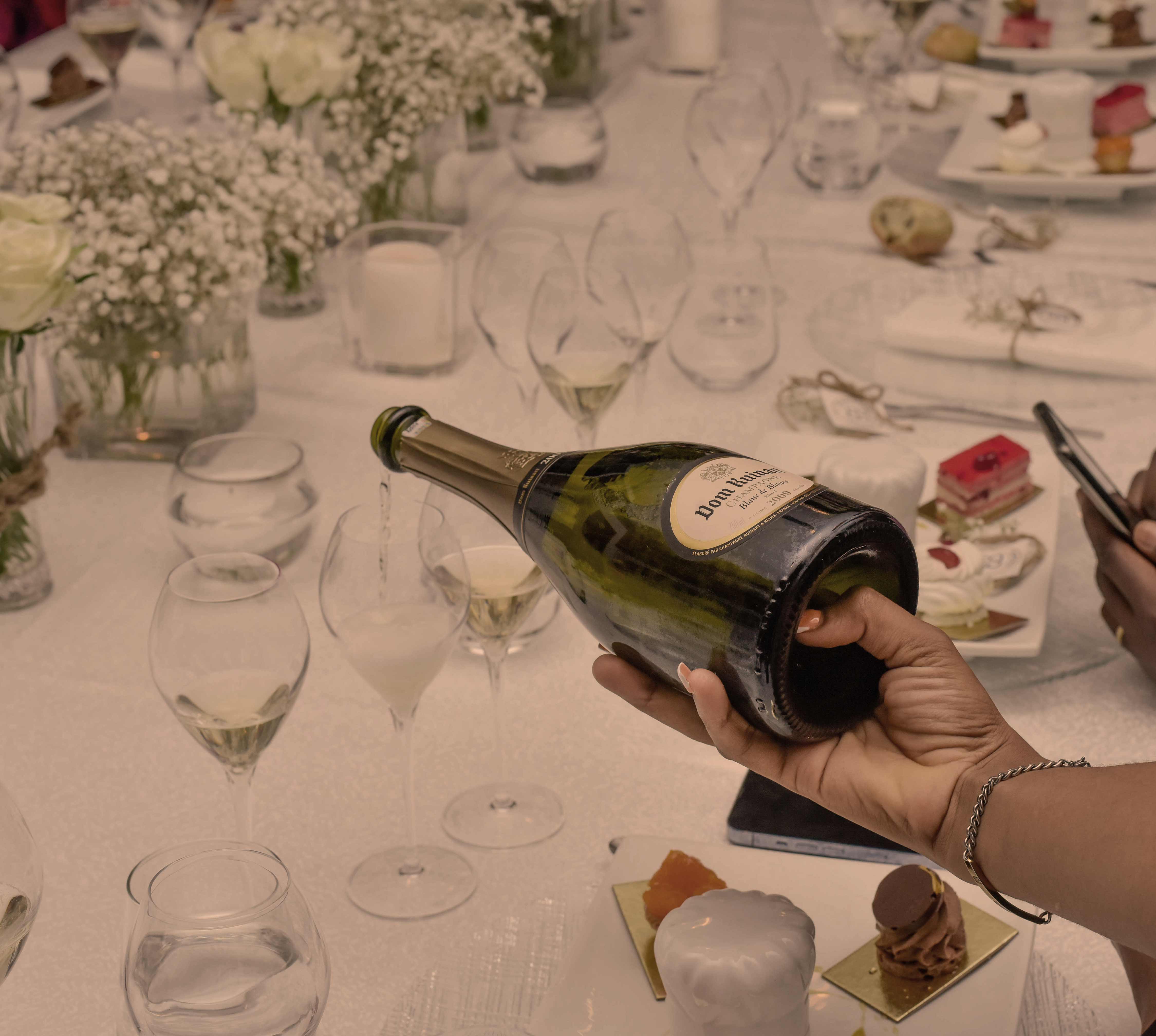 a person pouring wine into a glass