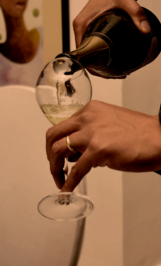 a person pouring a glass of wine